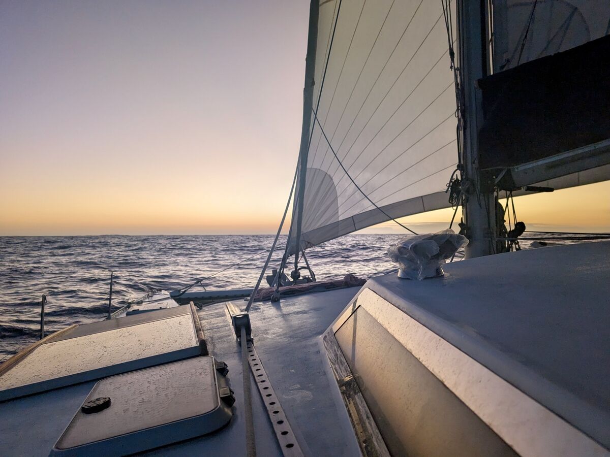 On deck under sail at sunset on the Pacific