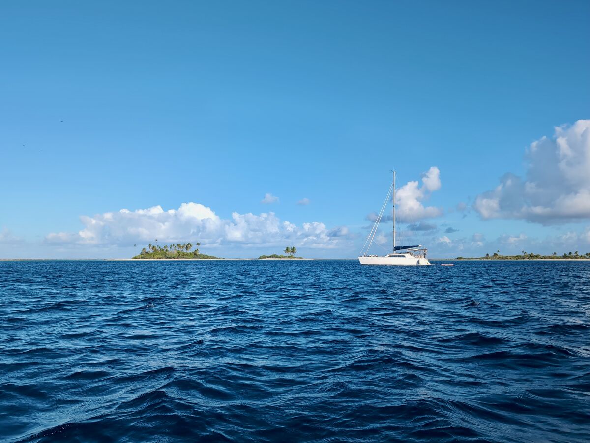 Zoë anchored off a palm-fringed motu
