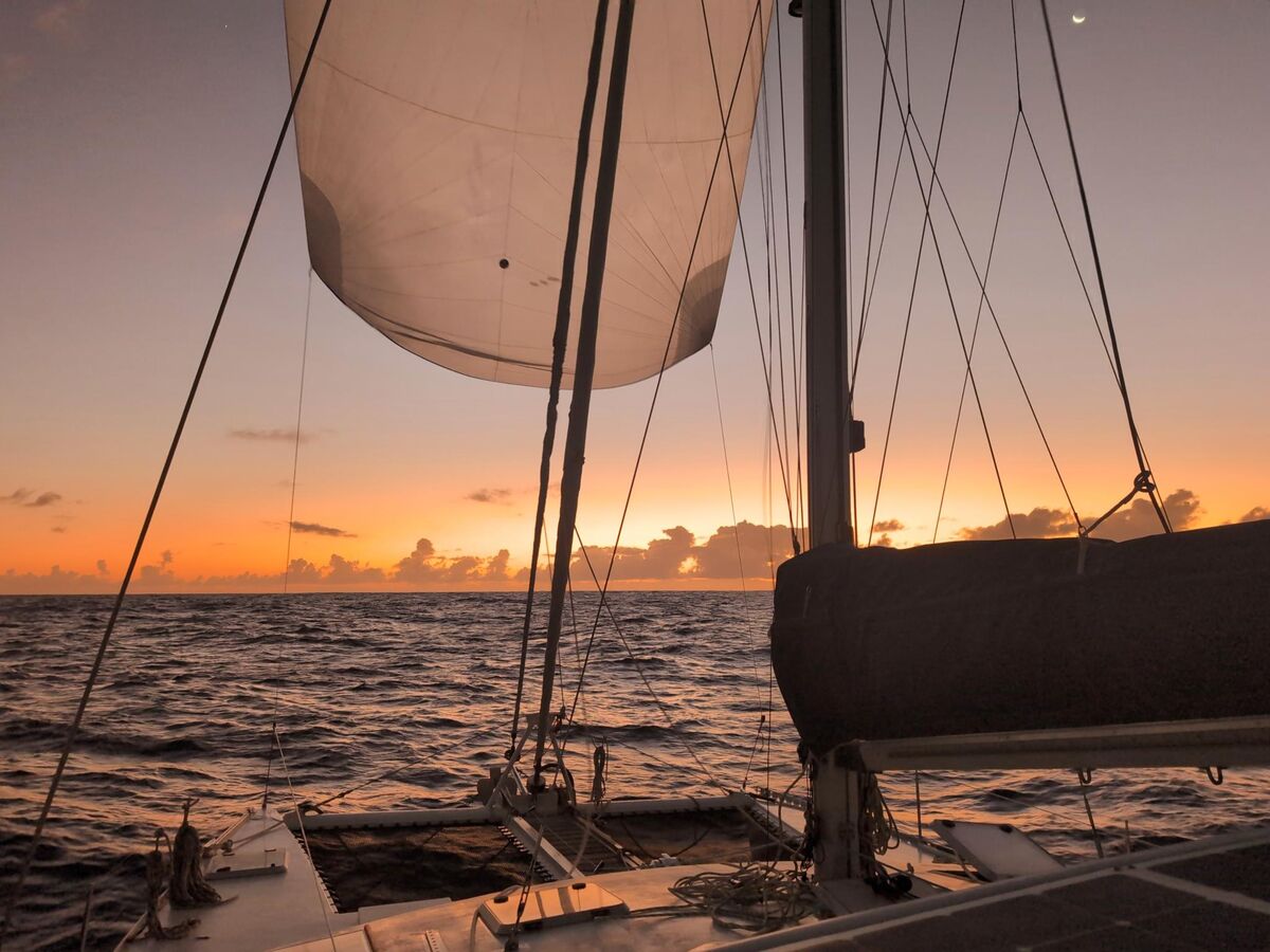 Sailing downwind under spinnaker at sunset