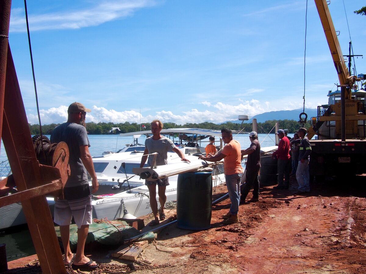 Stepping the mast alongside a barge in the Rio Dulce