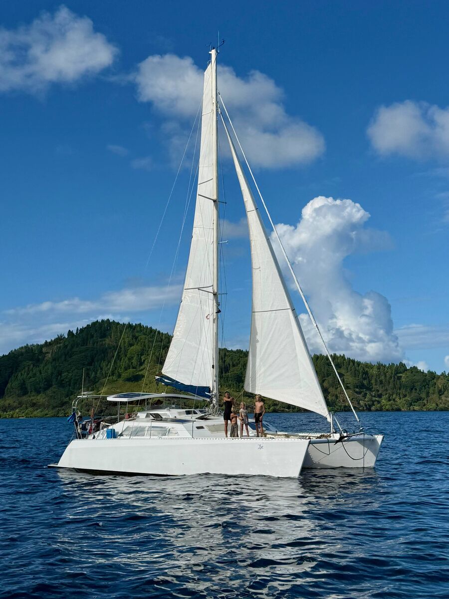 Zoë under full sail with the family on deck near the Gambier Islands